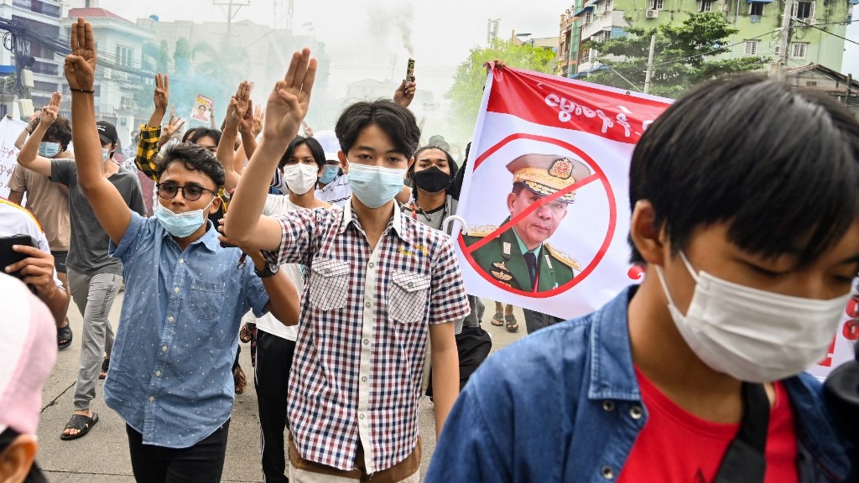 Manifestantes junto a una pancarta contra el jefe de la junta militar 